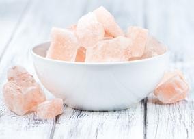 Pink Himalayan salt chunks in a white bowl